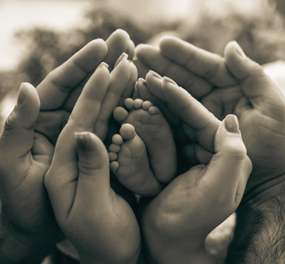 Hands holding hands holding baby's feet